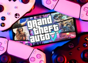 A smartphone displaying a concept logo for GTA 6, surrounded by gaming controllers.