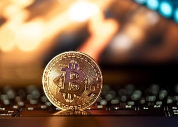 Bitcoin coin on keyboard with nice background. Crypto money concept.