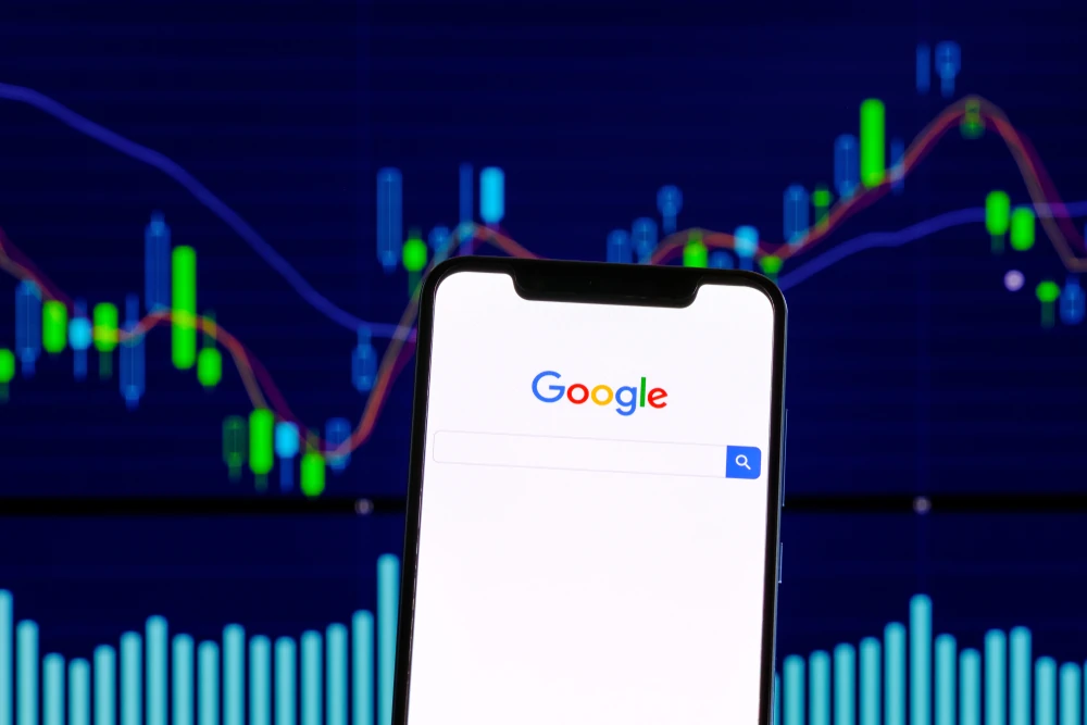 Stock photo of Google in front of financial charts